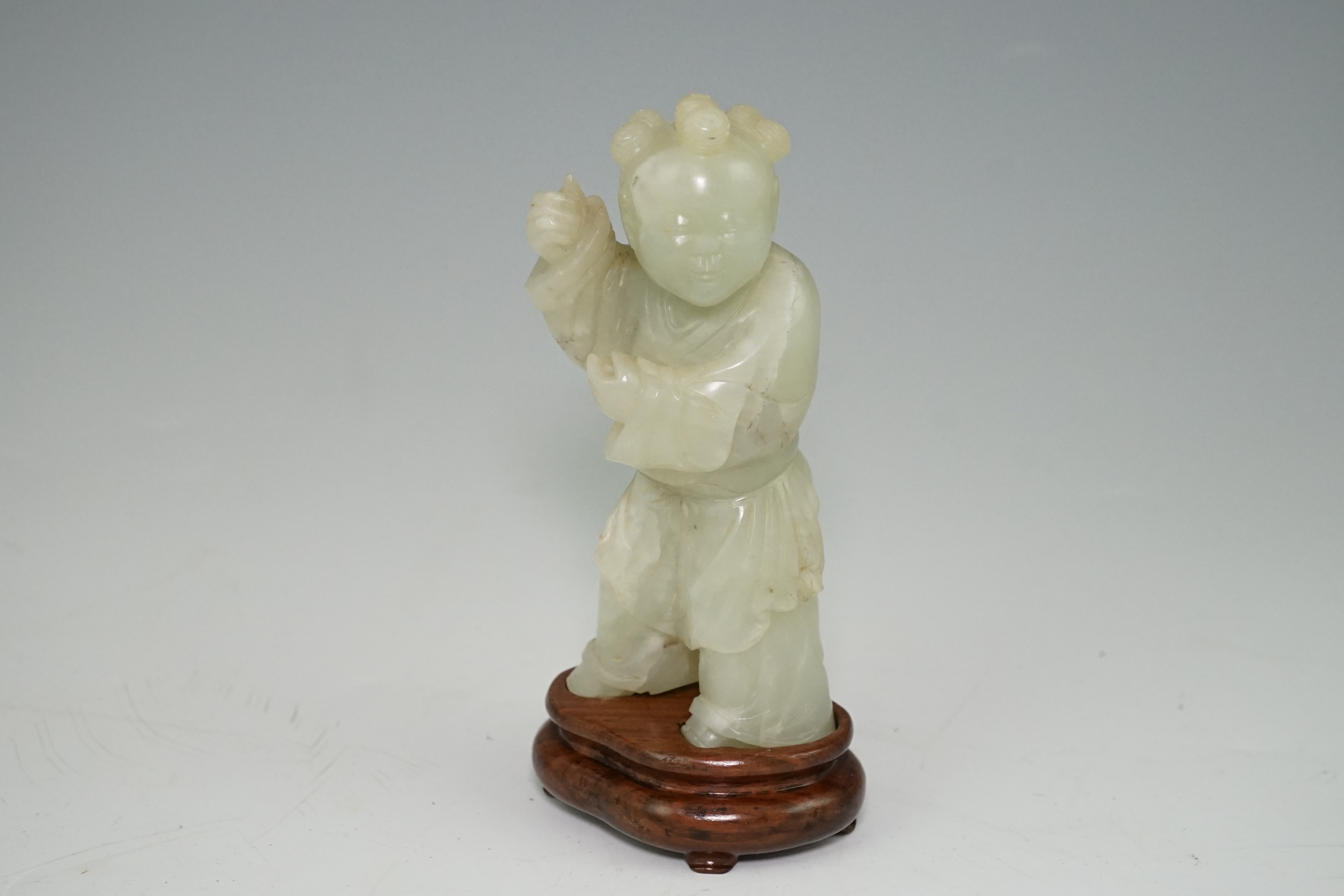 A Chinese pale celadon jade figure of a boy, 18th century